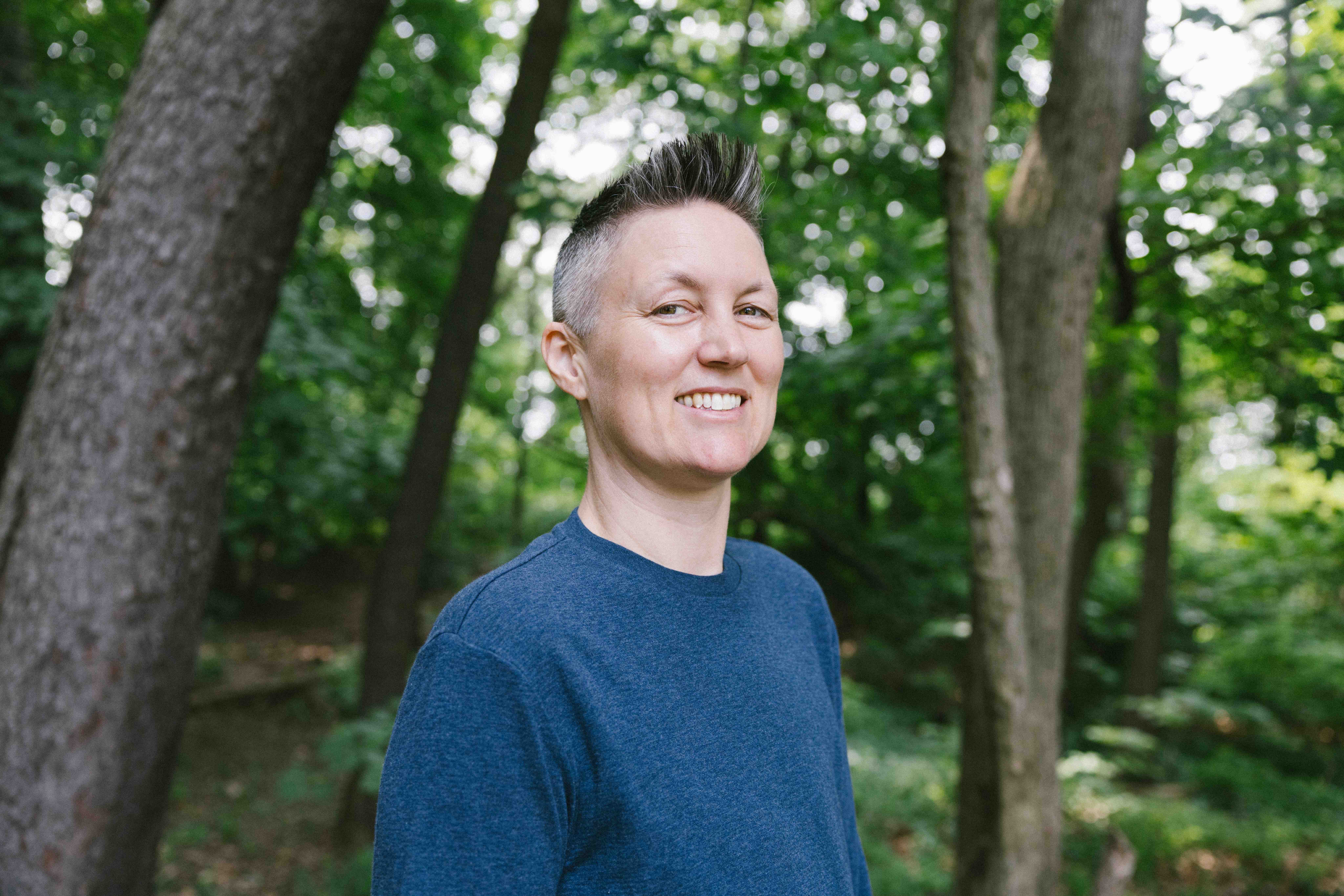 Bradley Dettmer in the forrest wearing a blue shirt